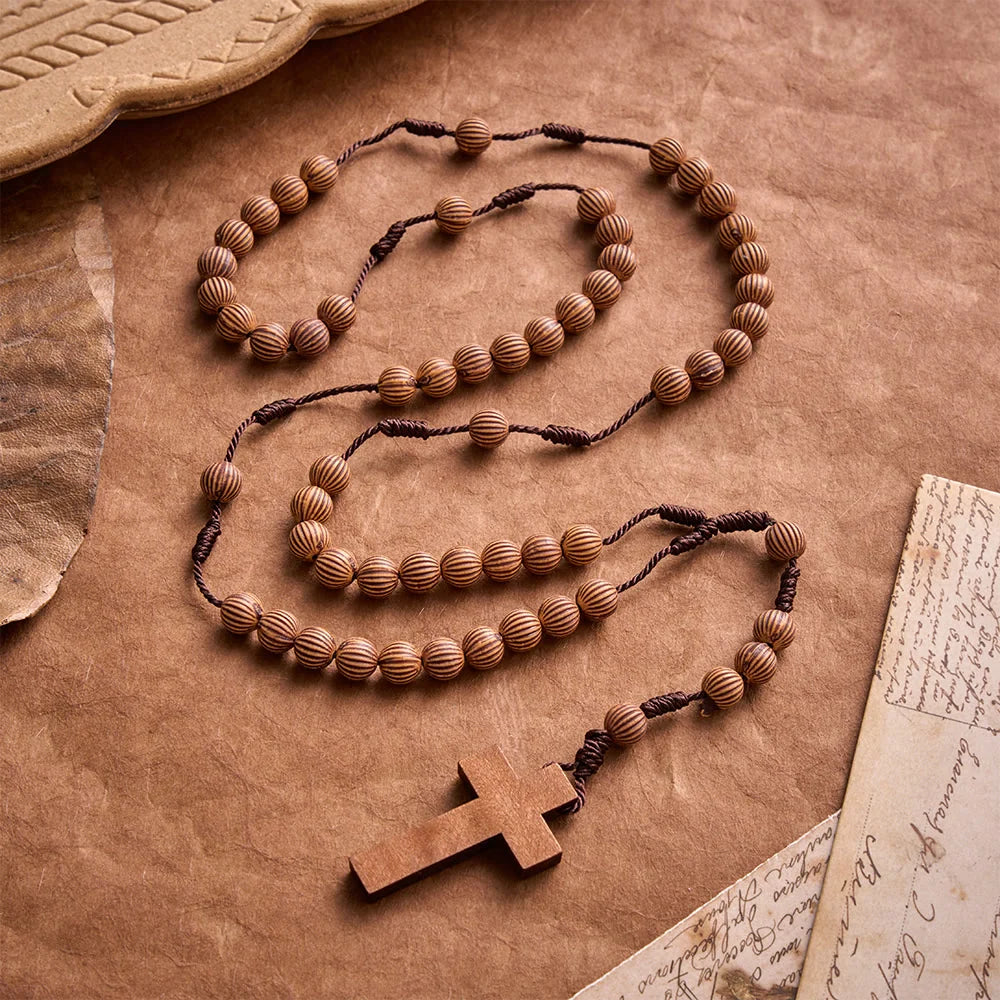 Rosario intrecciato in corda scura effetto legno con pendente a forma di croce: simbolo di un ornamento religioso essenziale