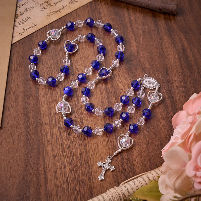 Rosario in vetro cavo a forma di cuore con perline sfaccettate blu scuro: segno di costante protezione divina
