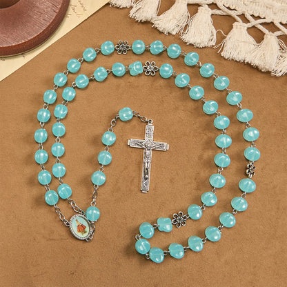 con una catenina in lega rosata, perline blu a forma di cubo, con l'icona della Madonna e un crocifisso