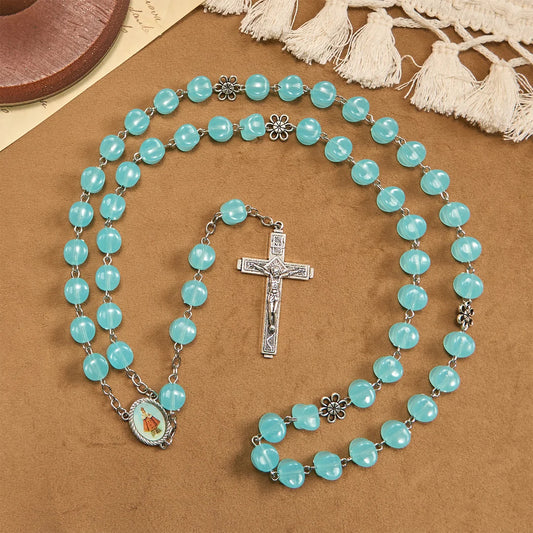 con una catenina in lega rosata, perline blu a forma di cubo, con l'icona della Madonna e un crocifisso