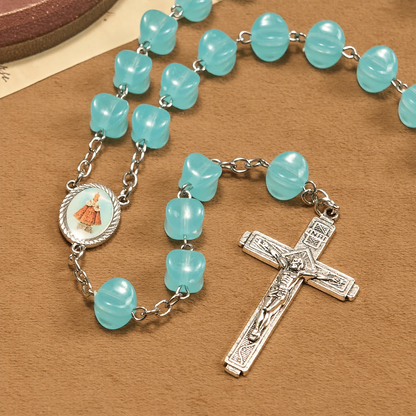 con una catenina in lega rosata, perline blu a forma di cubo, con l'icona della Madonna e un crocifisso