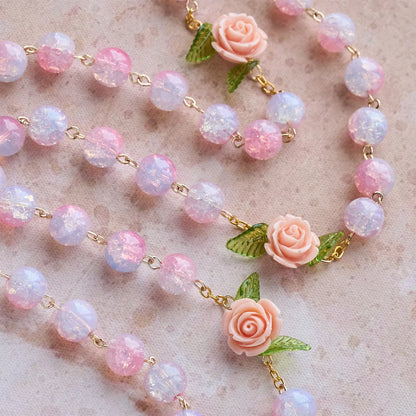 Vergine Maria con rosario e accento di rosa: fede senza tempo e simbolo floreale di devozione