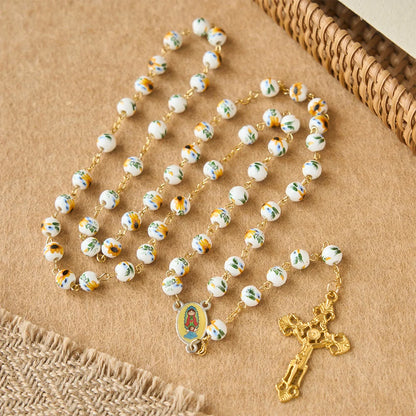 con margherite gialle, perline di ceramica e un ciondolo della Madonna