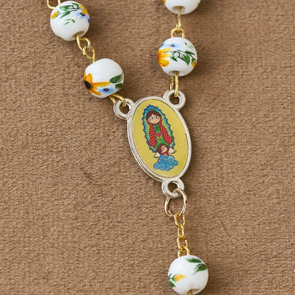 con margherite gialle, perline di ceramica e un ciondolo della Madonna