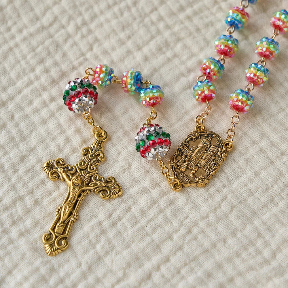 Rosario con perline arcobaleno a tema natalizio e croce dorata: devozione e fede viva