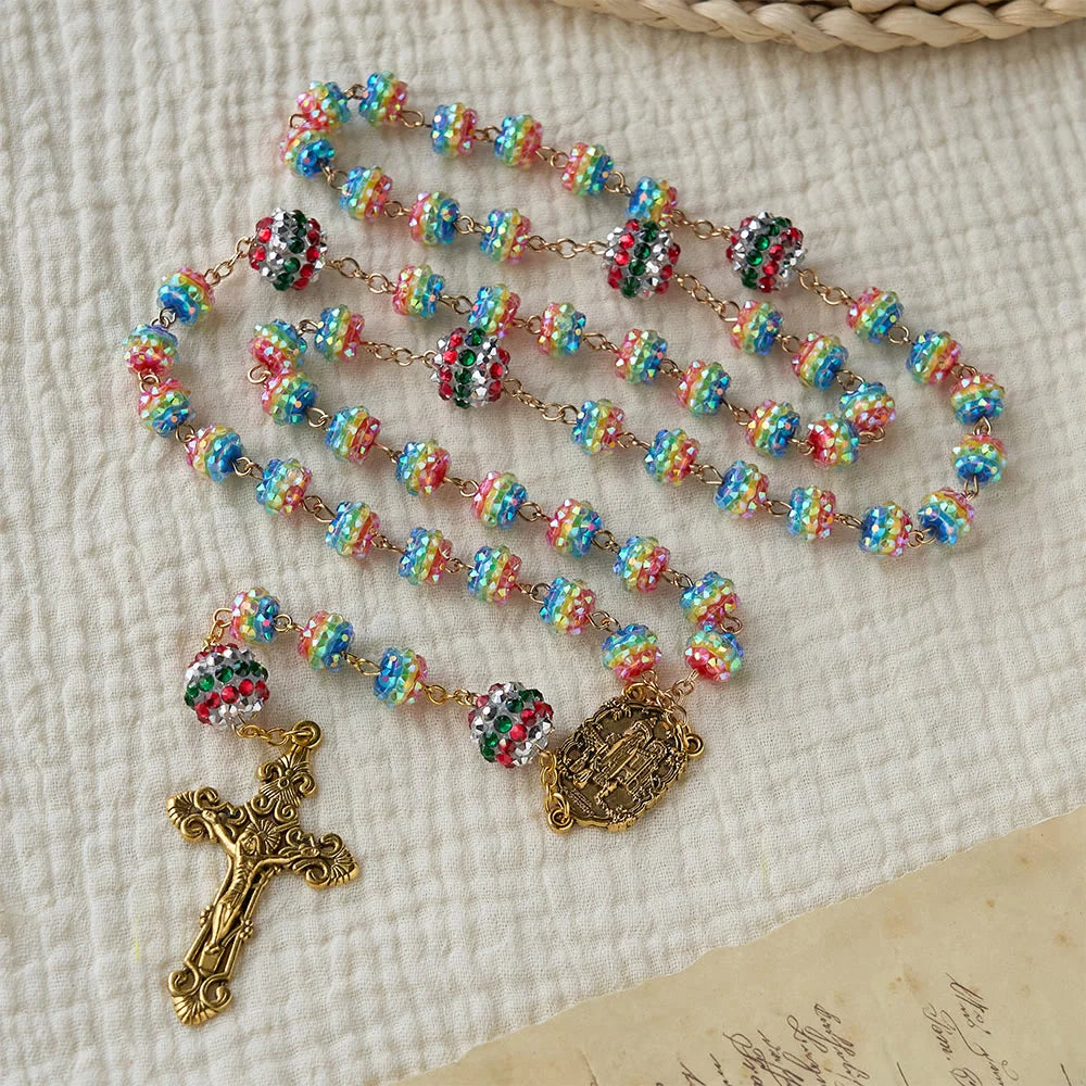 Rosario con perline arcobaleno a tema natalizio e croce dorata: devozione e fede viva
