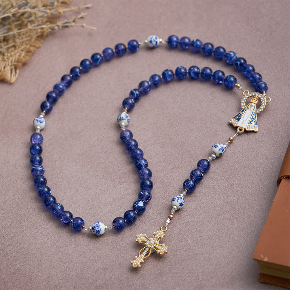 Rosario in vetro blu scuro craquelé e grani di porcellana con la Madonna di Aparecida al centro