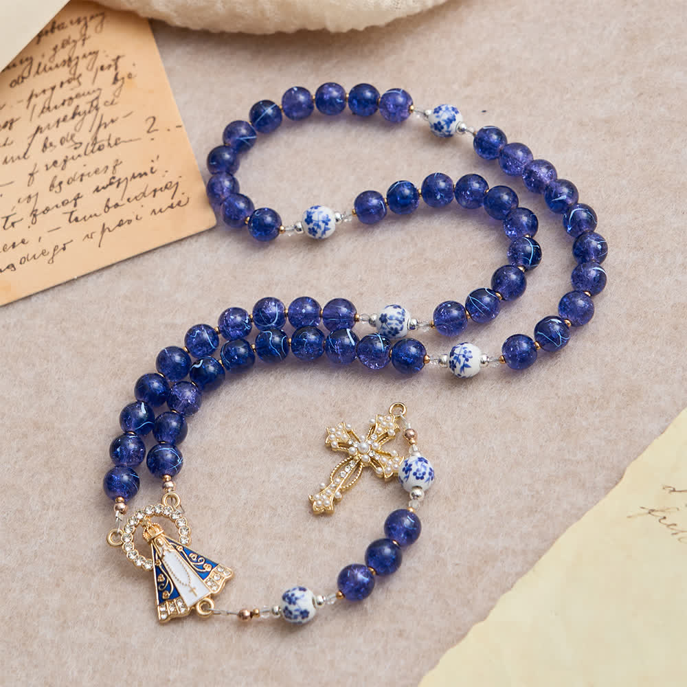 Rosario in vetro blu scuro craquelé e grani di porcellana con la Madonna di Aparecida al centro