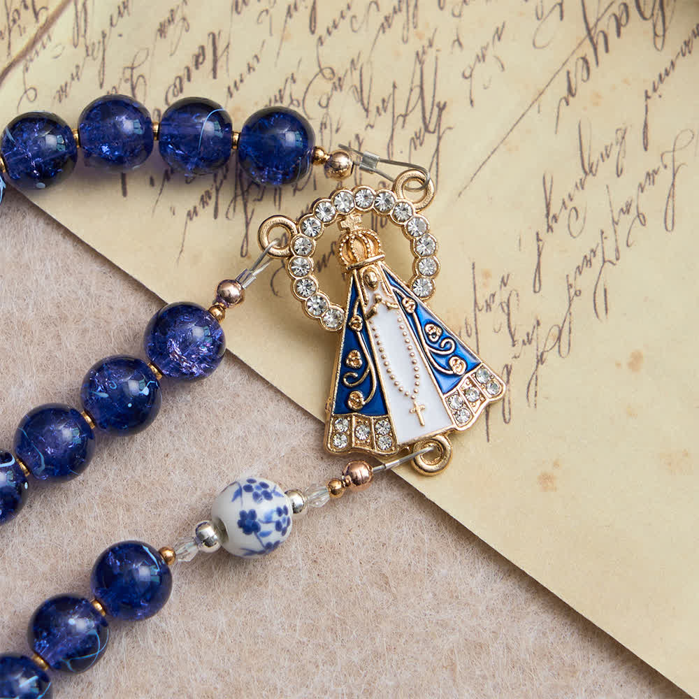 Rosario in vetro blu scuro craquelé e grani di porcellana con la Madonna di Aparecida al centro
