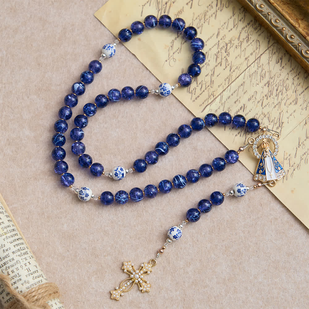 Rosario in vetro blu scuro craquelé e grani di porcellana con la Madonna di Aparecida al centro