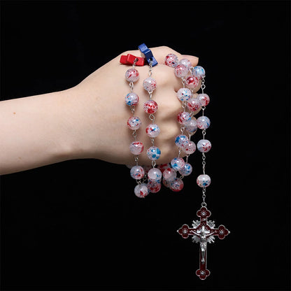 Perline a pois, accento patriottico a forma di stella, medaglione con lo scudo di San Michele, rosario in smalto, crocifisso a stella