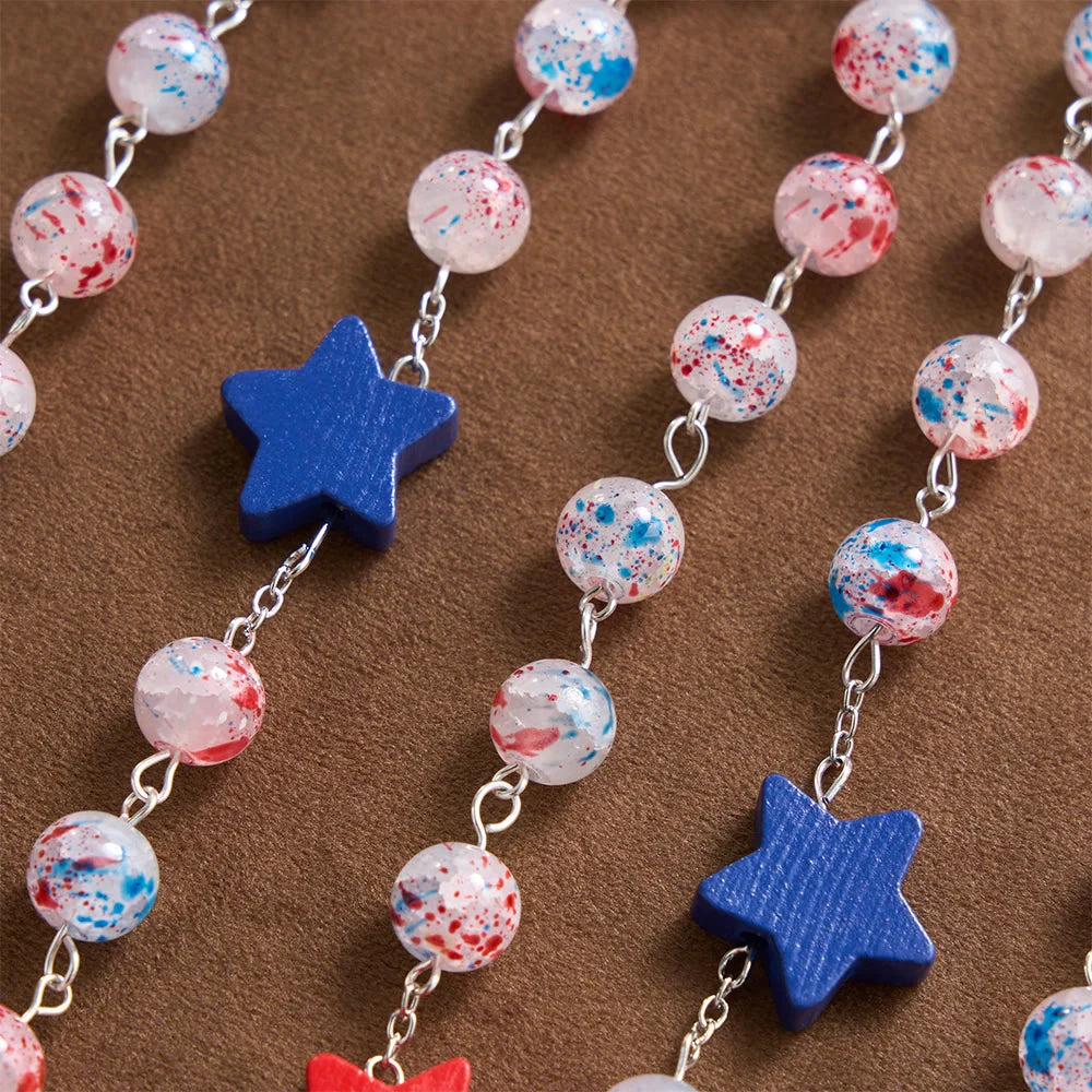 Perline a pois, accento patriottico a forma di stella, medaglione con lo scudo di San Michele, rosario in smalto, crocifisso a stella