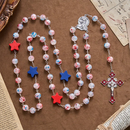 Perline a pois, accento patriottico a forma di stella, medaglione con lo scudo di San Michele, rosario in smalto, crocifisso a stella