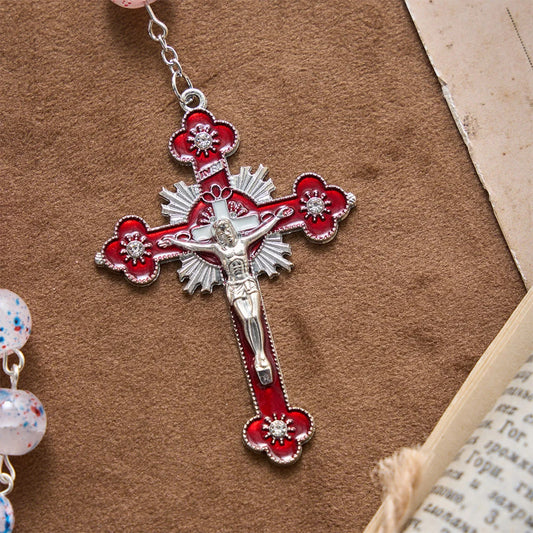 Perline a pois, accento patriottico a forma di stella, medaglione con lo scudo di San Michele, rosario in smalto, crocifisso a stella