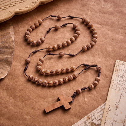 Rosario intrecciato in corda scura effetto legno con pendente a forma di croce: simbolo di un ornamento religioso essenziale