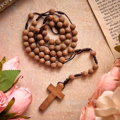 Rosario intrecciato in corda scura effetto legno con pendente a forma di croce: simbolo di un ornamento religioso essenziale
