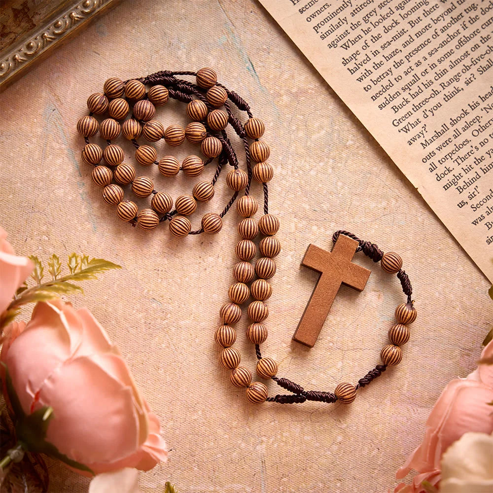 Rosario intrecciato in corda scura effetto legno con pendente a forma di croce: simbolo di un ornamento religioso essenziale