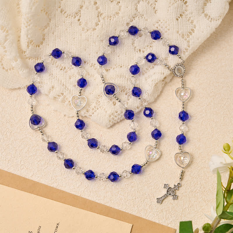 Rosario in vetro cavo a forma di cuore con perline sfaccettate blu scuro: segno di costante protezione divina