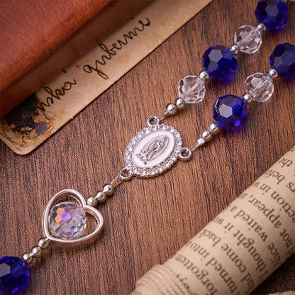 Rosario in vetro cavo a forma di cuore con perline sfaccettate blu scuro: segno di costante protezione divina