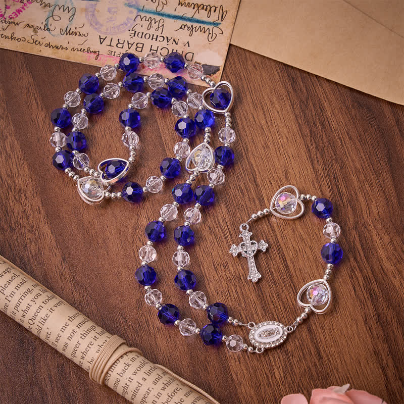 Rosario in vetro cavo a forma di cuore con perline sfaccettate blu scuro: segno di costante protezione divina