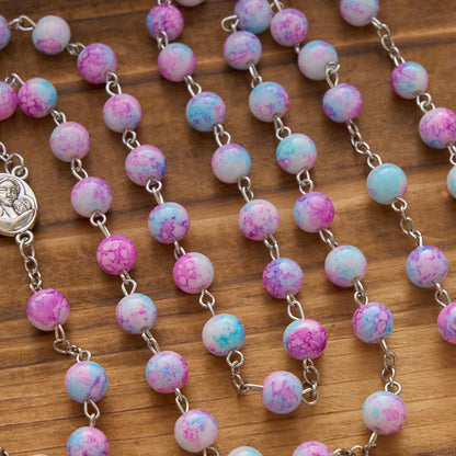 Rosario marmorizzato in perle di vetro rosa e azzurre con medaglia della Madonna con Bambino e crocifisso