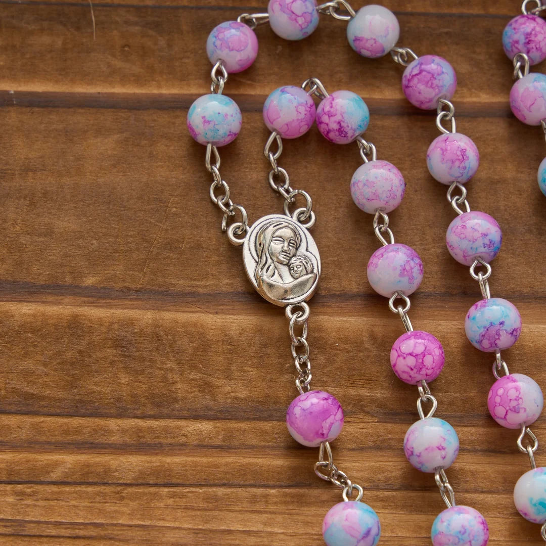 Rosario marmorizzato in perle di vetro rosa e azzurre con medaglia della Madonna con Bambino e crocifisso