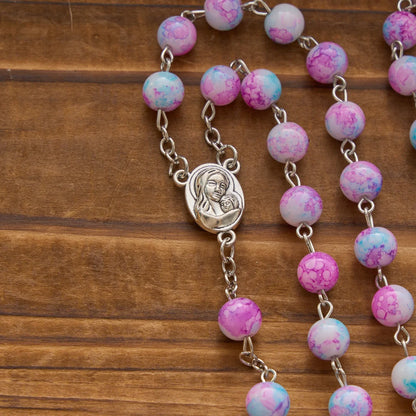 Rosario marmorizzato in perle di vetro rosa e azzurre con medaglia della Madonna con Bambino e crocifisso