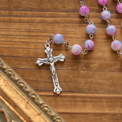 Rosario marmorizzato in perle di vetro rosa e azzurre con medaglia della Madonna con Bambino e crocifisso