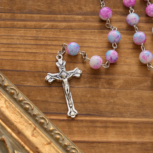 Rosario marmorizzato in perle di vetro rosa e azzurre con medaglia della Madonna con Bambino e crocifisso