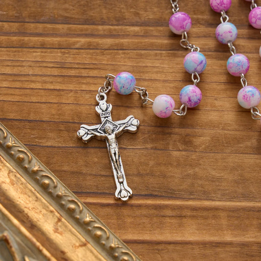 Rosario marmorizzato in perle di vetro rosa e azzurre con medaglia della Madonna con Bambino e crocifisso